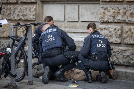 polizisten haben einen mann festgenommen. er liegt am boden.