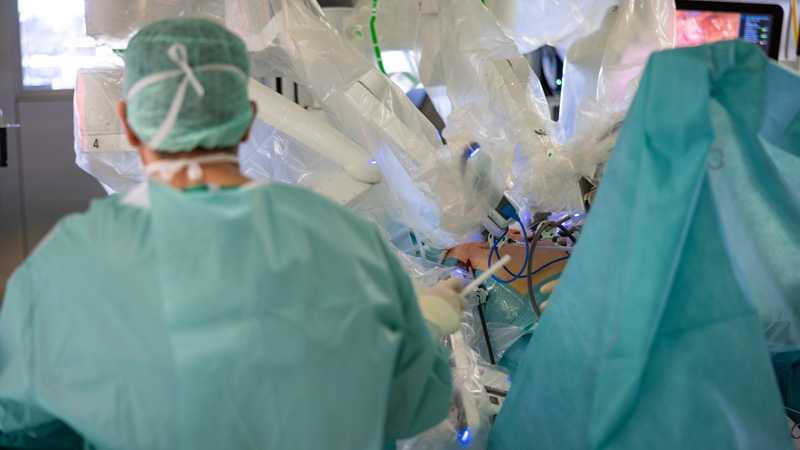 Chirurgenteam führt robotergestützte Operation mit einem da Vinci-System im OP-Saal durch.