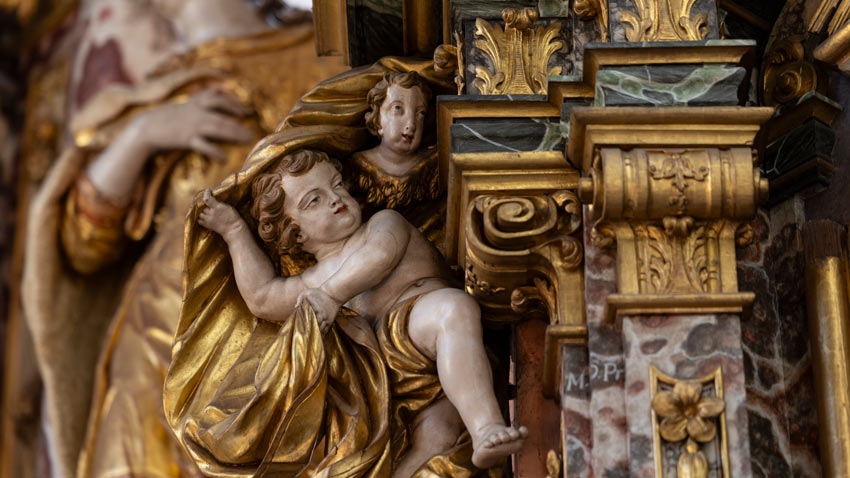 Detailaufnahme einer barocken Engelsfigur (Putte) mit Vergoldung am Hochaltar einer Kirche in Erfurt, sakrale Kunst und Bildhauerei.