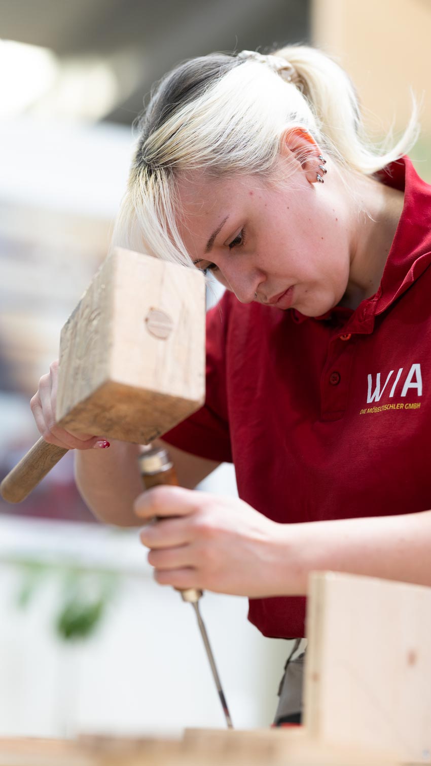 Auszubildende der W/A Die Möbeltischler GmbH stemmt Holz mit Klüpfel und Stechbeitel – Handwerk live auf der Messe Erfurt