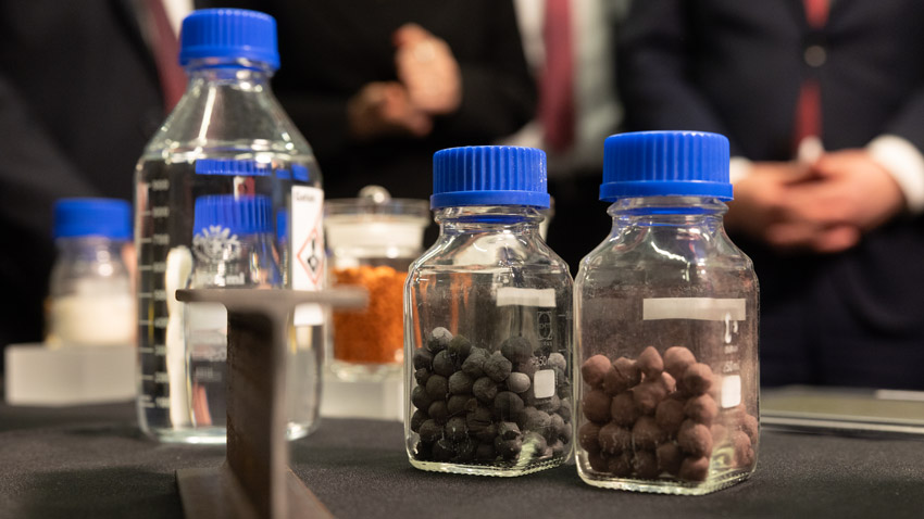 Keramikgranulat in Laborgläsern bei einer Institutsführung am Fraunhofer-Institut Hermsdorf, im Hintergrund unscharf Politiker der Besuchsdelegation – Fotoreportage von Paul-Philipp Braun