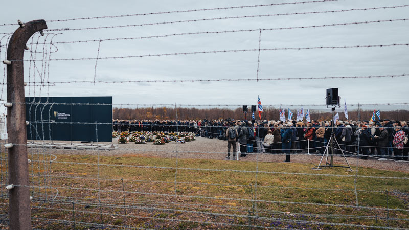 Blick durch den historischen Stacheldrahtzaun auf die Kranzniederlegung auf dem ehemaligen Appellplatz der Gedenkstätte Buchenwald, 81. Jahrestag der Befreiung, 12. April 2026