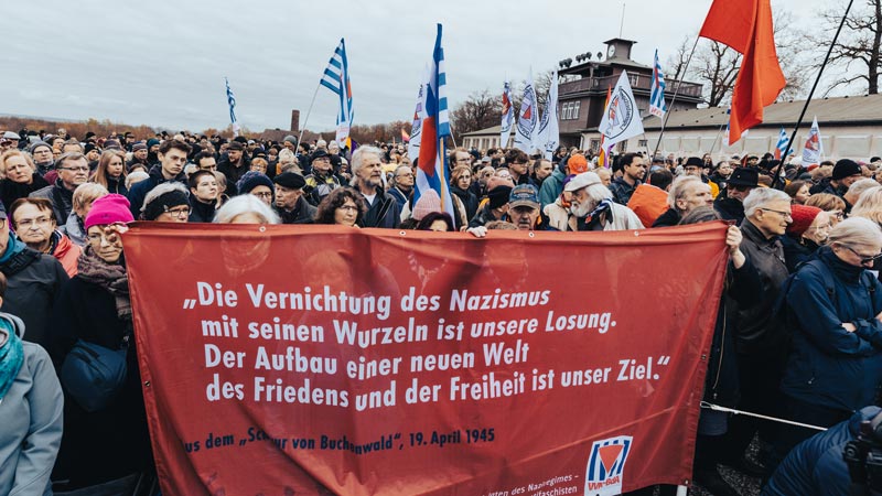 Blick durch den historischen Stacheldrahtzaun auf die Kranzniederlegung auf dem ehemaligen Appellplatz der Gedenkstätte Buchenwald, 81. Jahrestag der Befreiung, 12. April 2026