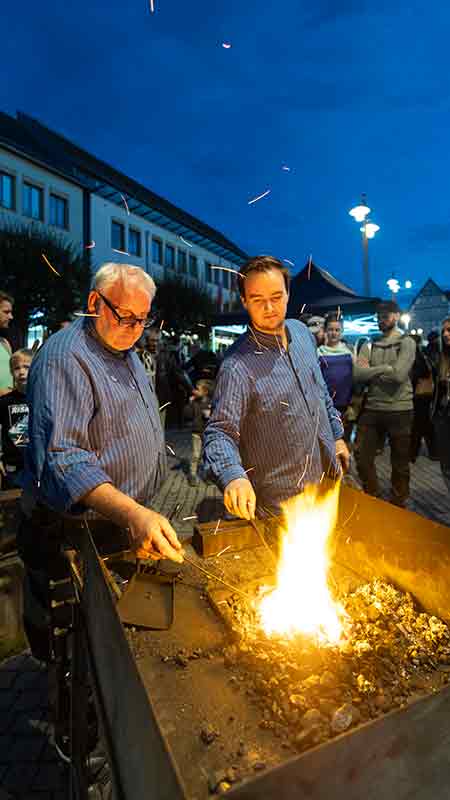 Zwei Schmiede bei der Arbeit an der Esse, Kinderkulturnacht in Eisenach Junge sitzt im Einsatzfahrzeug und lässt sich die Ausstattung erklären, Kinderkulturnacht in Eisenach