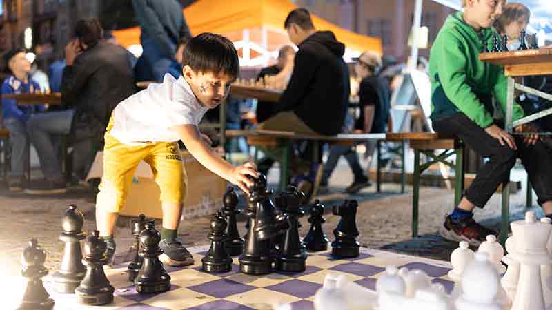 Junge spielt am überdimensionalen Schachbrett bei der Kinderkulturnacht in Eisenach