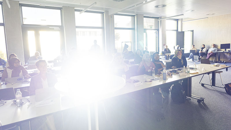 Tagungsraum der Konferenz God Human Machine an der Universität Erfurt mit internationalem Publikum, starkes Gegenlicht durch Fensterfront